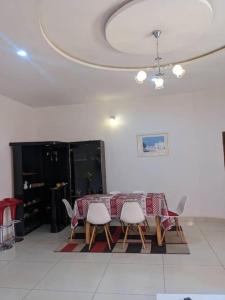 a dining room with a table and chairs and a ceiling at Élégante villa avec jardin+bar in Lomé