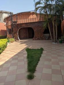 a patch of grass in the middle of a courtyard at Élégante villa avec jardin+bar in Lomé