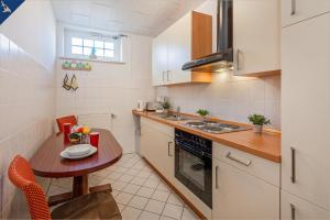 eine kleine Küche mit einem kleinen Tisch und einem kleinen Tisch mit einem Teller auf in der Unterkunft Villa Linde FeWo 1 in Ahlbeck