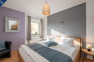 ein Schlafzimmer mit einem großen weißen Bett und einem Fenster in der Unterkunft Villa Linde FeWo 2 in Ahlbeck
