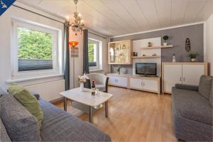 ein Wohnzimmer mit einem Sofa und einem Tisch in der Unterkunft Villa Linde FeWo 2 in Ahlbeck
