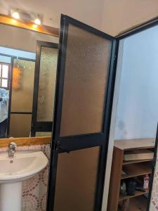ein Badezimmer mit einem Waschbecken und einer Schiebetür in der Unterkunft Élégante villa avec jardin+bar in Lomé