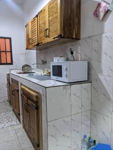 eine Küche mit einer Mikrowelle auf der Theke in der Unterkunft Élégante villa avec jardin+bar in Lomé