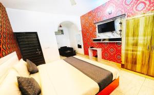 a bedroom with a bed and a tv on a wall at Hotel AELA Suites "Cloud plaza" near Delhi airport in New Delhi