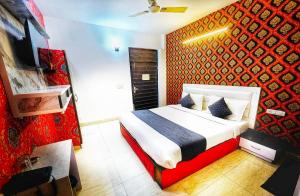 a bedroom with a bed with a red wall at Hotel AELA Suites "Cloud plaza" near Delhi airport in New Delhi