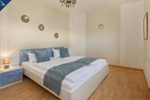 1 dormitorio con 1 cama grande con almohadas azules en Villa Linde FeWo 4, en Ahlbeck