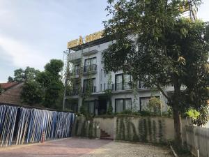 Ein weißes Gebäude mit einem Zaun davor. in der Unterkunft Thái Dương Hotel in Việt Trì