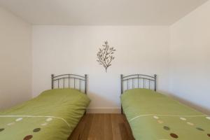 two beds in a room with green sheets at Trippet Cottage in Saint Breward