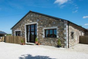 a stone house with two windows and a fence at Trippet Cottage in Saint Breward