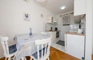 a kitchen with a table and chairs in a room at Apartments and rooms by the sea Barbat, Rab - 20049 in Rab