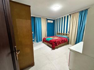 1 dormitorio con 1 cama en una habitación con paredes azules en Misr Al Gadedah Rooms, en El Cairo