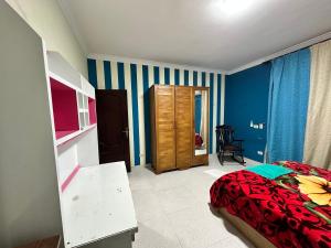 1 dormitorio con cama y rayas azules y blancas en Misr Al Gadedah Rooms, en El Cairo