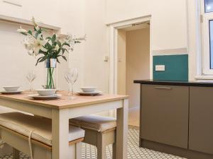 uma cozinha com uma mesa com um vaso de flores em Aquamarine em Scarborough