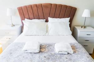 een slaapkamer met een bed met witte lakens en kussens bij Ataşehir's Most Luxurious Top Floor Residence in Istanbul