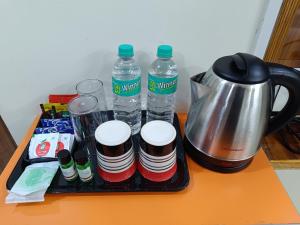 a tray with bottles of water and a coffee maker at J Beach Stay Rooms in Visakhapatnam