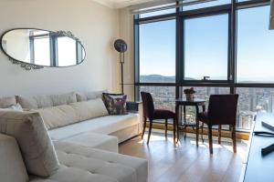 een woonkamer met een bank en een tafel met stoelen bij Ataşehir's Most Luxurious Top Floor Residence in Istanbul