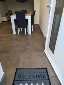 una esterilla de bienvenida en una habitación con mesa y sillas en Apartments with WiFi Ploce, Neretva Delta - Usce Neretve - 22723, en Ploče