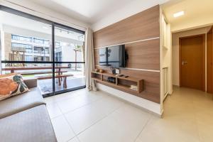 a living room with a couch and a tv at Apto Póximo a Praia de Barra de São Miguel - Destino BSM 106 A in Barra de São Miguel