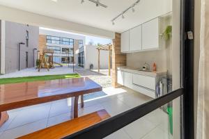 a kitchen with white cabinets and a table at Apto Póximo a Praia de Barra de São Miguel - Destino BSM 106 A in Barra de São Miguel