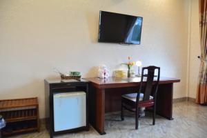 een bureau met een stoel en een televisie aan de muur bij Song Huong Hue Hotel in Hue