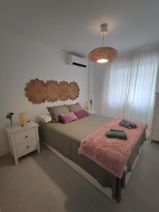 a bedroom with a large bed with a pink blanket at Apartamento Pilar in Seville