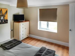 1 dormitorio con cama y ventana en The Lodge At Owstwick Hall 