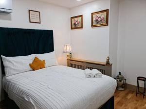 een slaapkamer met een bed met twee handdoeken erop bij SureBillionaire Homes II in Londen