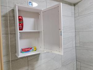 een witte kast in een badkamer met een douche bij SureBillionaire Homes II in Londen