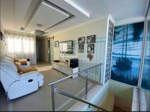 uma sala de estar com um sofá branco e uma escada em cobertura duplex no Rio de Janeiro