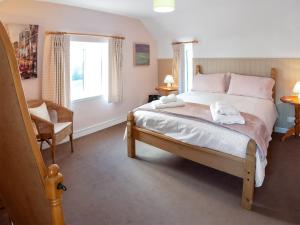 um quarto com uma cama, uma cadeira e uma janela em Cherry Tree Cottage - Uk46659 em Cheddar
