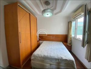 a bedroom with a bed and a cabinet and a window at cobertura duplex in Rio de Janeiro