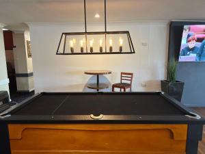 a pool table in a living room with a chandelier at The Commercial Hotel Wallerawang in Wallerawang