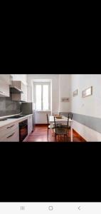 uma cozinha e sala de jantar com mesa e cadeiras em Cuore Di Roma Holidays em Roma
