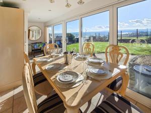 a dining room with a table and chairs and a large window at Estuary Retreat in Llanelli