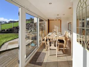 a dining room with a table and a balcony at Estuary Retreat in Llanelli