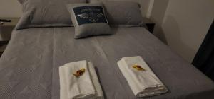 a bed with two towels and two butterflies on it at Departamento Studio con balcón en microcentro in Resistencia