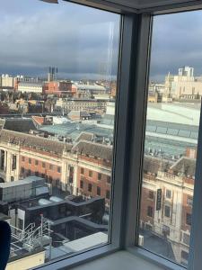 a view of a city from a window at Elegant two bedroom city central apartment in Leeds