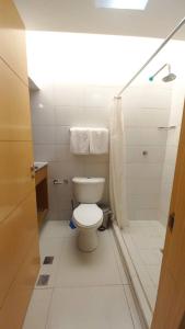 PH1401 Hotel Margarita Real في بورلامار: حمام ابيض مع مرحاض ودش