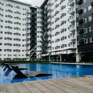 um grande edifício de apartamentos com uma escultura em frente em Alta Suites/2br/swimmingpool/city center/PS4 games em Cainta