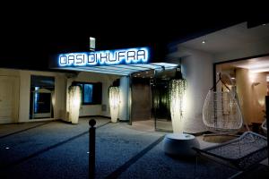 a building with a sign that reads osis de umra at Hotel Oasi Di Kufra in Sabaudia