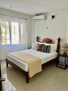 een slaapkamer met een groot bed met kussens erop bij Ocho Rios Oasis in St Mary