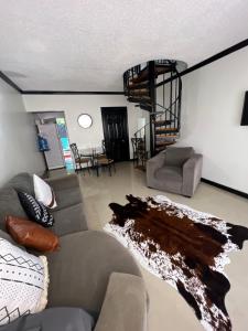 een woonkamer met een bank en een wenteltrap bij Ocho Rios Oasis in St Mary