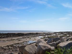 a group of rocks on a beach with the ocean at Kadelin Cove in Mainsriddle