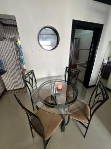 een glazen tafel met vier stoelen en een spiegel bij Ocho Rios Oasis in St Mary