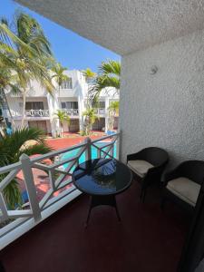 een balkon met een tafel en stoelen en palmbomen bij Ocho Rios Oasis in St Mary