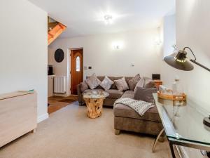 a living room with a couch and a table at Mews Cottage in Abergele