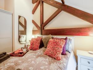 uma cama com almofadas num quarto em Mews Cottage em Abergele
