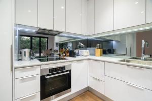 墨尔本Sophisticated art deco in the heart of Toorak的白色的厨房配有白色橱柜和电器