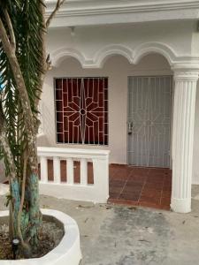 巴亞希貝的住宿－Hostel El Hoyo，两扇门和一棵棕榈树的房子
