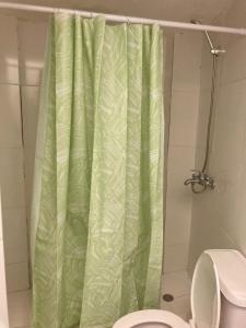 - un rideau de douche vert dans la salle de bains pourvue de toilettes dans l'établissement Hostel El Hoyo, à Bayahibe